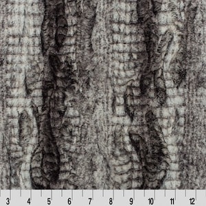 May include: Close-up of a gray and brown faux fur fabric with a textured, wood-like pattern.