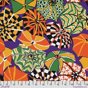 May include: A fabric print featuring a repeating pattern of stylised umbrellas in orange, green, black, and white against a purple background. The umbrellas display various designs including checkerboard, chevron, and floral motifs, with a 12-inch ruler visible.