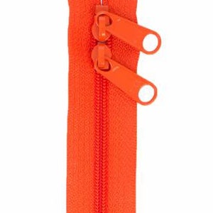 May include: A bright orange zipper with two pull tabs. The zipper is closed and ready to be sewn into a garment or project.