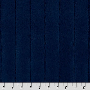 Puede incluir: Primer plano de una tela azul oscuro con textura acanalada vertical. La tela se mide en pulgadas.