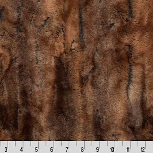 May include: Brown and black faux fur fabric with a striped pattern. The fabric has a soft, plush texture.