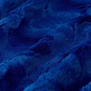 May include: A close-up of a soft, blue faux fur fabric. The fabric has a plush, velvety texture and a deep, rich blue colour.