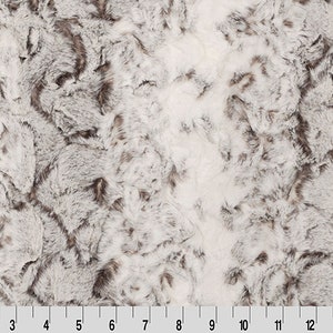 May include: White and gray faux fur fabric with a soft, fluffy texture.