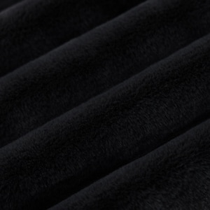 May include: Close-up of a black plush fabric with a soft, velvety texture.