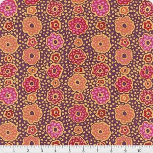 May include: A fabric swatch featuring a repeating floral pattern with pink, red, and orange flowers on a dark purple background with yellow speckles. A white ruler with black markings is visible at the bottom, measuring up to 10 inches.