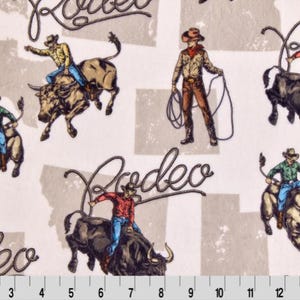 May include: Fabric with a rodeo theme. The design features cowboys riding bulls, with the word "Rodeo" in a cursive font. The color palette includes shades of brown, blue, red, and green on a light beige background.