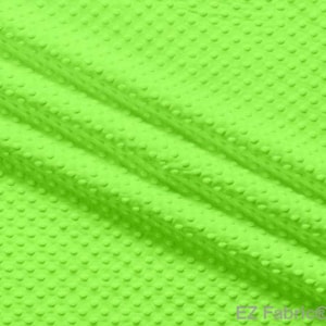 Könnte beinhalten: Ein leuchtend grüner Stoff mit einer strukturierten, gepunkteten Oberfläche. Der Stoff ist weich und plüschig und eignet sich daher ideal für Bastelprojekte oder die Herstellung von kuscheligen Decken.