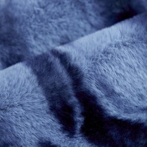 Op de afbeelding: Close-up van een zachte, blauwe nep bont stof met een subtiel tie-dye patroon.