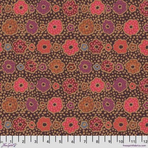May include: A fabric swatch featuring a repeating pattern of stylized flowers in shades of pink, orange, purple, and blue against a dark brown background with a speckled texture. A white ruler at the bottom shows a scale of 12 inches.