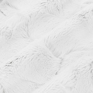 May include: White fluffy faux fur fabric with a soft, plush texture. The fabric has a subtle wave pattern.
