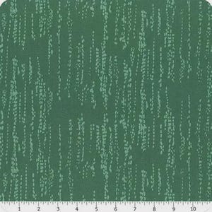 May include: A piece of fabric with a dark green background and a pattern of light green vertical lines composed of small dots. The fabric is measured with a ruler along the bottom edge.