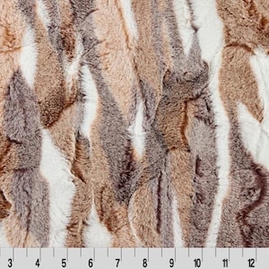 May include: Close-up of a faux fur fabric with a striped pattern in shades of brown, gray, and white.