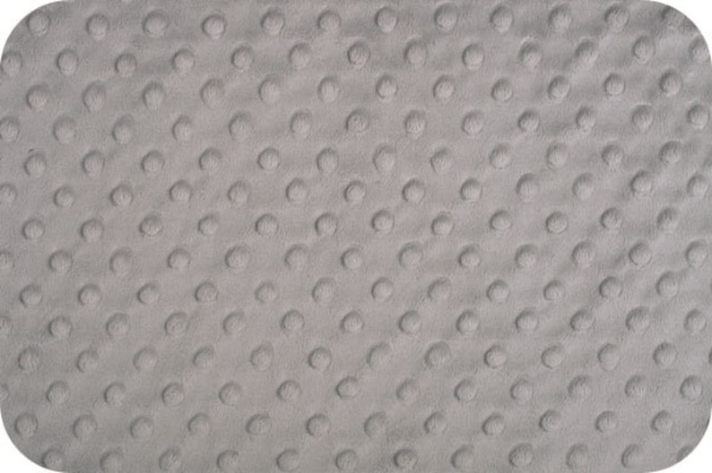 May include: A close-up of a gray textured fabric with a repeating pattern of small raised dots.