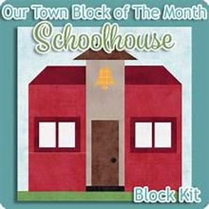 May include: A quilt block pattern titled Our Town Block of The Month Schoolhouse. The design features a red schoolhouse with a central tower, a brown door, a yellow bell icon, and white windows, set against a light blue background.
