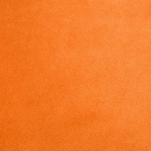 Könnte beinhalten: Ein einfarbiger orangefarbener Filzstoff mit leicht strukturierter Oberfläche.