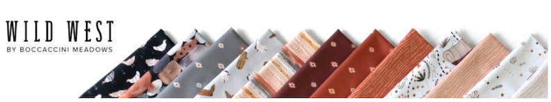 Pu&ograve; includere: L'immagine mostra campioni di tessuto piegati in fila, con il testo "WILD WEST" e "BY BOCCACCINI MEADOWS" sopra. I tessuti presentano vari motivi, tra cui disegni floreali e geometrici, in colori come nero, grigio e ruggine.