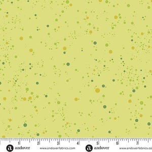 May include: A yellow fabric with a scattered pattern of small green and yellow circles. The fabric has a ruler with inches marked on it and the text "Andover" printed on it.