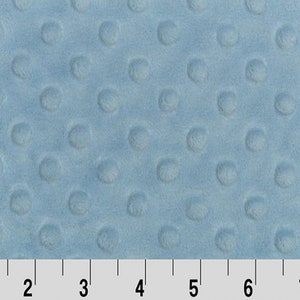 May include: A close-up of a light blue minky fabric with a textured dot pattern. The fabric is measured in inches.