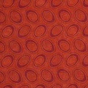Könnte beinhalten: Nahaufnahme eines Stoffes mit einem sich wiederholenden Muster aus ovalen Formen. Der Stoff hat ein strukturiertes Aussehen mit einem rötlich-orangen Hintergrund und dunkleren roten ovalen Designs. Die Ovale sind leicht geneigt und erzeugen einen dynamischen visuellen Effekt.