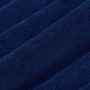 May include: Close-up of a deep blue fabric with a soft, fuzzy texture. The fabric is folded and shows the texture and depth of the material.