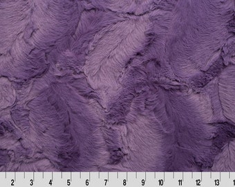 Peut inclure: Tissu en fausse fourrure violet avec une texture douce et moelleuse. Le tissu présente un effet ombré subtil, avec des nuances de violet clair et foncé.