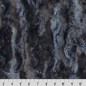 May include: A close-up of a soft, plush fabric with a blue and gray marbled pattern. The fabric has a fuzzy texture and a luxurious feel.