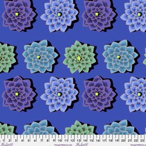 May include: A repeating pattern of stylized flowers in shades of blue, purple, and green on a deep blue background. The flowers have a layered petal design with a yellow center. A ruler is at the bottom of the image.