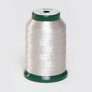 May include: A spool of silver metallic thread with a green plastic bobbin. The spool is labeled "MT181 MS 1 1000m".