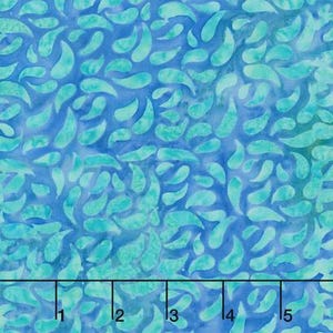 May include: A blue and teal fabric featuring a repeating pattern of small, curved, petal-like shapes. A black ruler is visible at the bottom of the image, showing measurements in inches from 1 to 5, indicating the scale of the textile design.