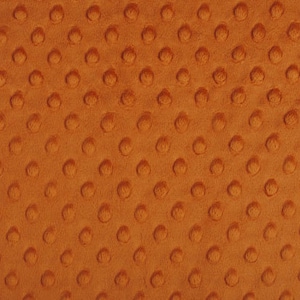 Könnte beinhalten: Nahaufnahme eines strukturierten Stoffes mit einem sich wiederholenden Muster aus kleinen, erhabenen Kreisen. Der Stoff ist tief orangefarben.