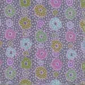 May include: A fabric with a repeating floral pattern. The flowers are in shades of pink, green, and blue, with yellow centers, set against a gray background dotted with small purple circles. The fabric's design is a repeating pattern.