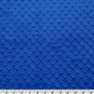 May include: A close-up of a blue fabric with a textured, raised dot pattern.