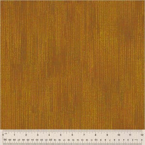 May include: Close-up of a textured fabric with a vertical stripe pattern in shades of gold and brown. A ruler is placed at the bottom of the fabric, showing measurements in inches.