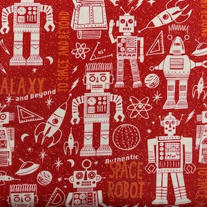 May include: Red fabric with a repeating pattern of white robots, rockets, planets, and space-themed elements. Text includes "GALAXY and Beyond" and "Authentic SPACE ROBOT".
