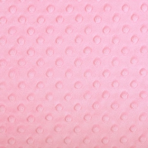 Può includere: Primo piano di un tessuto minky rosa con un motivo a punti testurizzati.