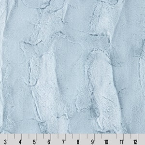 May include: A close-up of a light blue faux fur fabric with a soft, plush texture.