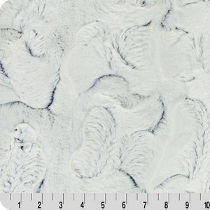 Puede incluir: Tela de piel sintética blanca con un patrón de remolino en color azul claro. La tela es suave y mullida, y sería perfecta para hacer mantas, almohadas u otros artículos de decoración del hogar.