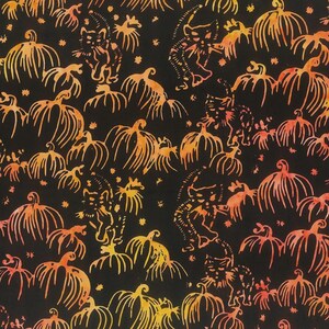 May include: A black fabric featuring a repeating pattern of orange and yellow gradient pumpkins and cats. The design includes small star-like shapes scattered throughout the print, creating a dense, continuous motif across the entire surface.
