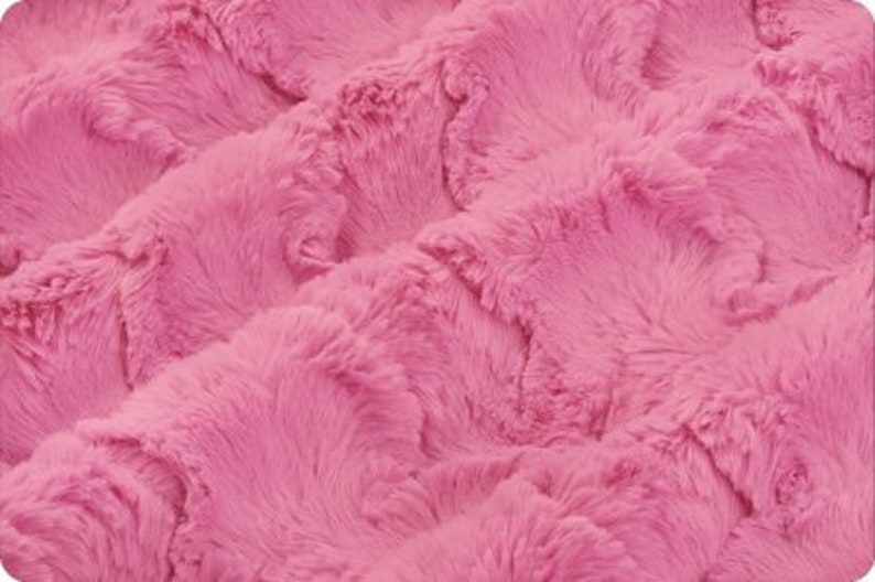 May include: Pink fluffy fabric with a wavy, textured pattern. The fabric is soft and plush, with a luxurious feel.