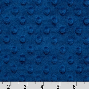 May include: A close-up of a blue minky fabric with a textured dot pattern. The fabric is soft and plush, perfect for baby blankets, quilts, and other sewing projects.