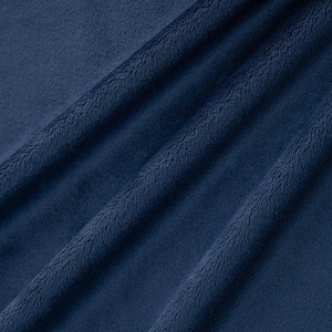 May include: Close-up of a soft, blue fabric with a fuzzy texture. The fabric is folded and draped, showing the texture and folds.