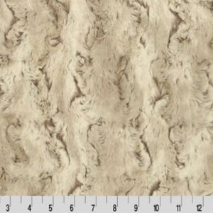 Puede incluir: Tela de piel sintética de color crema con un patrón ondulado y texturado. La tela tiene un tacto suave y mullido.