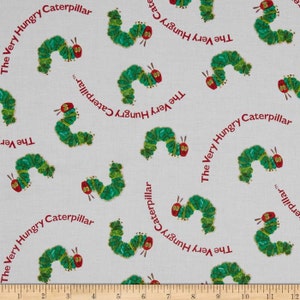 Puede incluir: Tela con un patrón repetido de orugas verdes con cabezas rojas y el texto "The Very Hungry Caterpillar" en rojo. Las orugas están sobre un fondo gris claro. La tela se mide en centímetros.