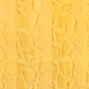 Puede incluir: Primer plano de una tela de piel sintética amarilla con una textura suave y esponjosa.