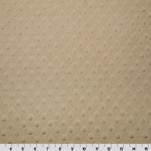 May include: A close-up of a beige fabric with a textured pattern of small, raised circles.
