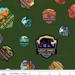 May include: Green fabric featuring various National Park patches, including Zion, Great Smoky Mountains, and Petrified Forest. The patches are in various colors and shapes, with text indicating the park names and locations.