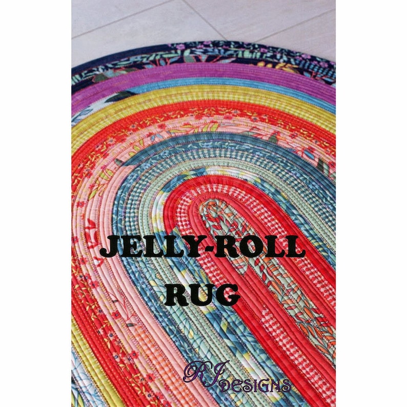 May include: A colorful, oval-shaped rug made from strips of fabric sewn together. The rug is made in a rainbow pattern with red, orange, yellow, green, blue, indigo, and violet stripes. The text "JELLY-ROLL RUG" is printed in black letters on the rug.