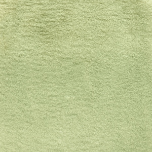 Pode incluir: Close-up de um tecido macio de cor verde claro com uma textura felpuda.