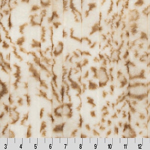 Pu&ograve; includere: Tessuto in pelliccia sintetica bianca con strisce marroni. Il tessuto ha una texture morbida e soffice.