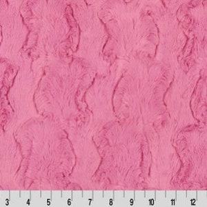 May include: Pink faux fur fabric with a textured, wavy pattern. The fabric has a soft, plush feel.